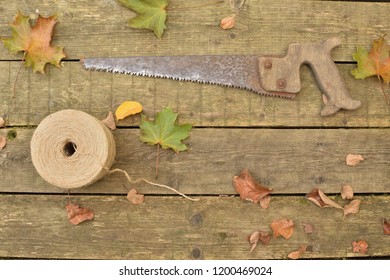 Autumn Composition With Antique Hand Saw, Twine On A Wooden Table Top View, Copy Space