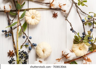 Autumn Composition Background. Frame Made Of Dried Fall Flowers, Pumpkins, Branches And Autumn Leaves, Also Cotton, Clove And Sloe. Top View On White Wood, Flat Lay, Copy Space