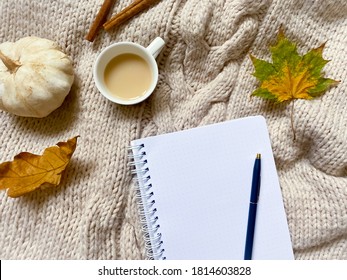 Autumn composition.  blank white notebook, pen, cup with tea with milk, pumpkin, cinnamon sticks, autumn maple and oak leaves on a knitted cozy background.  Top view, flat lay, copy space - Powered by Shutterstock