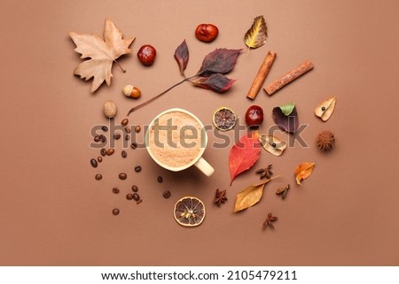 Autumn composition with cup of coffee on color background