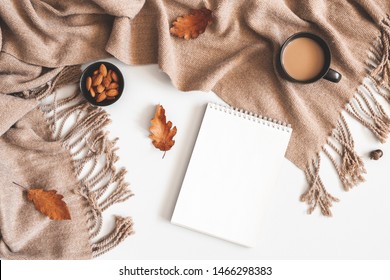 Autumn composition. Cup of coffee, plaid, notepad, autumn leaves on white background. Flat lay, top view, copy space - Powered by Shutterstock