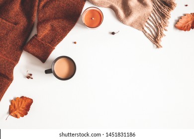 Autumn composition. Cup of coffee, sweater, plaid, autumn leaves on white background. Flat lay, top view, copy space
