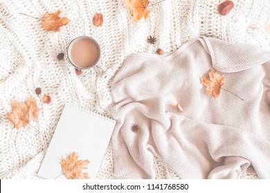 Autumn composition. Cup of coffee, women fashion sweater, dried leaves, plaid, notebook. Autumn, fall concept. Flat lay, top view, copy space - Powered by Shutterstock