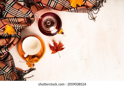 Autumn Composition. A Cup Of Tea And Teapot, Scarf, Autumn Leaves. Flat Lay, Top View, Copy Space. High Quality Photo