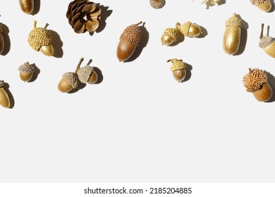 Autumn composition with golden painted acorns oak tree on white light background. Autumnal Still life image with natural materials. Autumn, fall concept. Minimal flat lay, top view, copy space