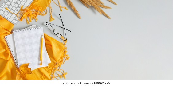 Autumn Composition. Home Office Workspace, Female Desk With Empty Notebook, Keyboard, Scarf, Dry Leaves On Isolated Grey Background. Autumn, Fall Business Concept. Flat Lay, Top View, Copy Space