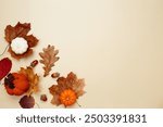 Autumn composition with maple leaves, decorative pumpkins and candles. Top view. Copy space