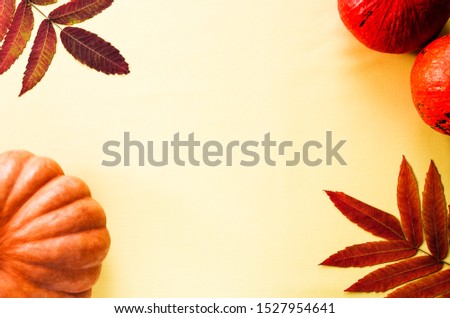 Autumn composition. Pumpkins and colorful autumn leaves on yellow background. Thanksgiving concept. Top view, copy space
