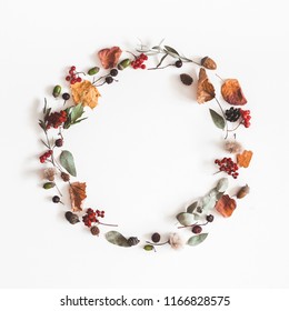 Autumn composition. Wreath made of eucalyptus branches, rose flowers, dried leaves on white background. Autumn, fall concept. Flat lay, top view, copy space, square