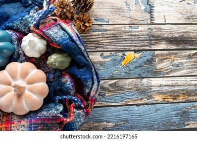 Autumn concept flatlay, top down view, with blue plaid scarf, pumpkins and pine cones - Powered by Shutterstock