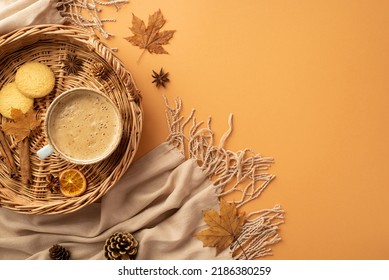 Autumn concept. Top view photo of wicker tray with cup of coffee cinnamon sticks cookies dried orange slice anise yellow maple leaves scarf and pine cones on isolated orange background - Powered by Shutterstock