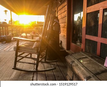 Autumn Country front porch with rocking chair at sunset with sun burst at golden hour