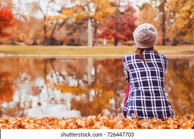 Autumn Cozy Background, Beautiful Woman Sitting Near The Lake In Fall Season