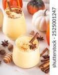 Autumn cozy drink, pumpkin spice eggnog cocktail, with honey, cinnamon sticks and anise stars, delicious dessert fall seasonal beverage 