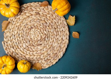 
Autumn Cozy Table Setting Background. Top View Of Wicker Place Mat, Pumpkins, Autumn Leaves On Dark Table. Autumnal Hygge Table Setting. Restaurant Menu. Copy Space