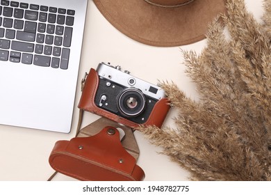 Autumn Creative Composition. Beige Reeds Branches, Camera, Hat And Laptop On Beige Background. Travel Concept. Flat Lay