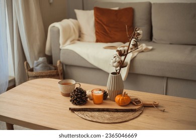 Autumn decor. Hot drink. Mug of tea, book, pumpkin, candle on a wooden coffee table. Autumn. Fall. - Powered by Shutterstock