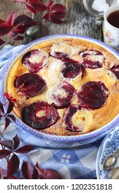 Autumn dessert. Red plums clafoutis and cup of coffee, icing sugar dressing, french cuisine - Shutterstock ID 1202351818
