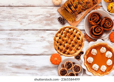 Autumn desserts side border. Table scene with an assortment of traditional fall sweet treats. Above view over a white wood background. Copy space. - Shutterstock ID 2365584499