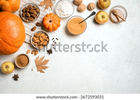 Autumn fall baking background with pumpkins, apples, nuts, food ingredients and seasonal spices, top view, copy space. Cooking pumpkin or apple pie for Thanksgiving and autumn holidays.
