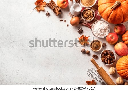 Autumn fall baking composition with pumpkins, apples, nuts, food ingredients and seasonal spices on white background, top view, copy space.  Thanksgiving and autumn holidays concept.