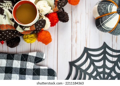 Autumn Fall Composition. Coffee Cup With A Knit Scarf, Fabric Plaid Pumpkin, Spiderweb And An Oven Mitt Baking Concept. Flat Lay, Top Down View, Copy Space