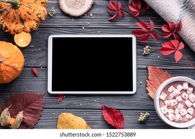 Autumn fall holiday background with pumpkin orange leaves cocoa cup tablet computer blank empty screen mock up on brown wooden table, happy halloween thanksgiving shopping sale, above top view - Powered by Shutterstock