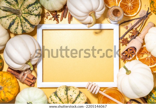 Autumn fall pumpkin spice baking and drink\
ingredients. Various colorful pumpkins, nuts, seasonal spices on\
golden background. Cooking pumpkin pie, latte, cookies for autumn\
Thanksgiving holidays