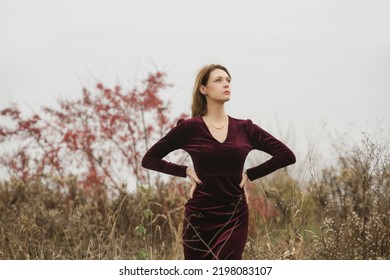 Autumn Fashion Outdoor Portrait Of Young Woman In Purple Red Plush Velvet Midi Dress. 