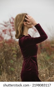 Autumn Fashion Outdoor Portrait Of Young Woman In Purple Red Plush Velvet Midi Dress. 