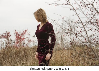 Autumn Fashion Outdoor Portrait Of Young Woman In Purple Red Plush Velvet Midi Dress. 