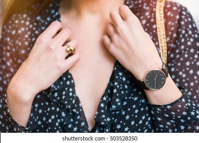 autumn fashion outfit details. trendy accessories, beautiful black and golden watch. fashion blogger wearing a see through delicate shirt with a deep neckline.