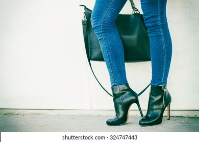 Autumn Fashion Outfit. Fashionable Woman Long Legs In Denim Pants Black Stylish High Heels Shoes And Handbag Outdoor On City Street