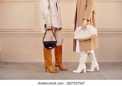 Autumn fashion two women in trendy clothes coat, high boots, bags . Street style outfit