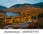 Autumn Female Adventure Hiker Sitting on Edge of Mountain Epic View From Artist Bluff Trail New Hampshire Beautiful Foliage Scenery Lake Yellow Coat