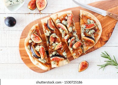 Autumn Flat Bread Pizza With Figs, Caramelized Onions, Blue Cheese And Rosemary. Top View Table Scene On A White Wood Background.