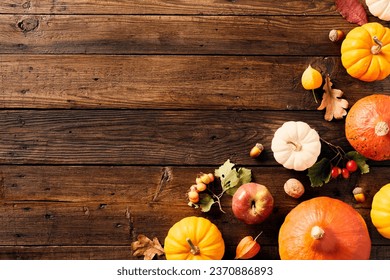 Autumn flat lay composition with pumpkins, acorns, berries, oak leaves on wooden table.