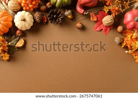 Autumn flat lay with pumpkins, pinecone, acorn, leaf, wheat on brown background. Seasonal harvest composition with copy space for fall, Thanksgiving or festive design