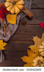 Autumn flat lay. Pumpkins and yellow leaves on knitted plaid. Wooden background. Space for text. - Shutterstock ID 1545423695