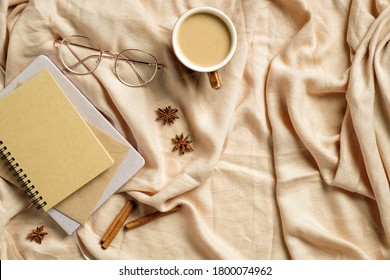 Autumn Flatlay Composition. Paper Notebook, Glasses, Coffee Cup On Beige Plaid. Autumn Hygge Style Desk Table Or Winter Holiday Concept.