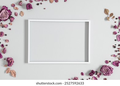 Autumn floral background with dry roses and white photo frame. Beautiful dried roses on gray background with space for advertising, text. Top view, flat lay. - Powered by Shutterstock