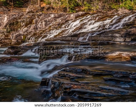 The Autumn flow of McDonald Creek reveals the step like appearance of Sacred Dancing Cascade.