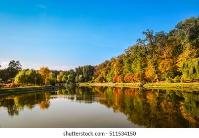 Autumn foliage, maple tree branches against lake and sky. Sunny day in Feofania park, Kyiv, Ukraine - Shutterstock ID 511534150