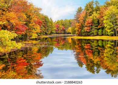 Autumn foliage reflections in calm pond water in New England - Shutterstock ID 2188840263