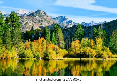 Autumn foliage of trees in a mountain forest. Mountain lake in autumn. Autumn lake in mountains. Autumn landscape