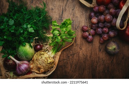 Autumn Food Background With Vegetables, Root Crops And Fruits In String Bag: Celery, Carrots, Apples, Pomegranate, Figs, Grapes. Harvesting, Local Farm Market Shopping, Healthy Eating Concept. 