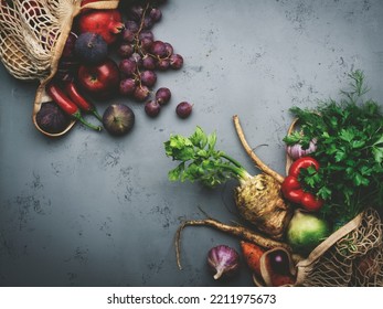 Autumn Food Background With Vegetables, Root Crops And Red Fruits In String Bag: Celery, Carrots, Apples, Pomegranate, Figs, Grapes. Harvesting, Farm Market Shopping