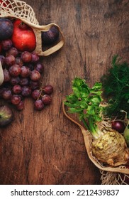 Autumn Food Background With Vegetables, Root Crops And Fruits In String Bag: Celery, Carrots, Apples, Pomegranate, Figs, Grapes. Harvesting, Local Farm Market Shopping, Healthy Eating Concept. 