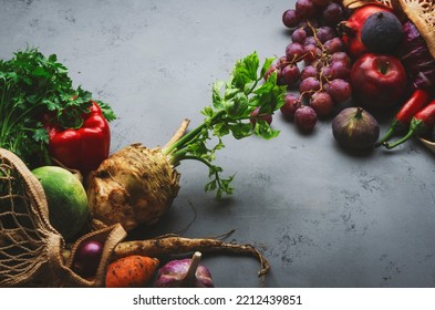 Autumn Food Background With Vegetables, Root Crops And Red Fruits In String Bag: Celery, Carrots, Apples, Pomegranate, Figs, Grapes. Harvesting, Local Farm Market Shopping, Healthy Eating Concept. 