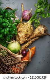 Autumn Food Background With Vegetables, Root Crops In String Bag: Celery, Radish, Parsnips, Carrots. Harvesting, Local Farm Market Shopping, Healthy Eating Concept. Top View